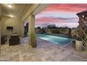 Gorgeous outdoor area with a covered patio, lush landscaping, and a sparkling pool with a travertine tile deck at 20594 S 194Th Pl, Queen Creek, AZ 85142