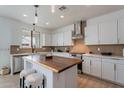 Modern kitchen featuring white cabinets, wooden accents, stainless steel appliances, and stylish pendant lighting at 21266 E Via De Olivos --, Queen Creek, AZ 85142