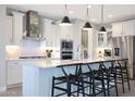 Bright, modern kitchen featuring a large island with seating, stainless steel appliances, and stylish pendant lighting at 26764 W Ponderosa Ln, Buckeye, AZ 85396