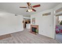 Cozy living room with a fireplace, ceiling fan, and sliding door to the outside patio at 3830 E Lakewood E Pkwy # 2009, Phoenix, AZ 85048