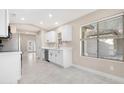 Bright kitchen featuring white cabinets, stainless steel appliances, and a view to the backyard through a large window at 44321 Cypress Ln, Maricopa, AZ 85138