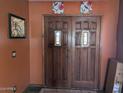 Warm interior view of a double front door with decorative accents and orange walls at 45020 N 18Th St, New River, AZ 85087