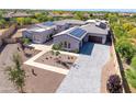 Aerial view of custom home featuring tile roof, solar panels, desert landscaping, and three-car garage at 5237 E Montgomery E Rd, Cave Creek, AZ 85331