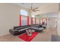 Bright living room with high ceilings, large windows, plush carpeting, and stylish modern furniture at 6219 W Navajo Dr, Glendale, AZ 85302