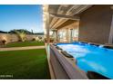 Outdoor oasis featuring a hot tub, artificial turf, and a covered patio at 6515 W Copper Springs Rd, Phoenix, AZ 85083