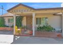 Inviting front porch with brick flooring, a comfortable seating area, and well-maintained landscaping at 901 E Hearn Rd, Phoenix, AZ 85022