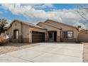 Inviting single-story home featuring a tile roof, desert landscaping, and a two-car garage at 9325 W Elwood St, Tolleson, AZ 85353