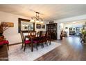 Elegant dining room with wood floors, chandelier, decorative mirror, and seating for six at 10106 W Highwood Ln, Sun City, AZ 85373