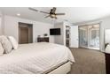 Serene main bedroom featuring plush bedding, a ceiling fan, and access to the backyard outdoor space at 10547 E Relativity Ave, Mesa, AZ 85212