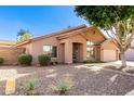 Inviting single-story home featuring desert landscaping, a cozy front entrance, and an attached two-car garage at 1077 E Loma Vista St, Gilbert, AZ 85295