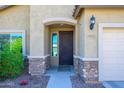 Stylish front door with stone accents and desert landscaping offers an inviting curb appeal at 10817 W Swayback Pass, Peoria, AZ 85383