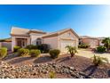 Inviting single-story home with desert landscaping, a two-car garage and a beautiful tile roof at 11029 W Oraibi Dr, Peoria, AZ 85373