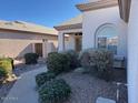 Well-maintained front yard featuring rock landscaping and mature shrubs near the entrance at 11029 W Oraibi Dr, Peoria, AZ 85373