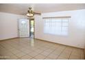 Neutral living area featuring tile flooring, a ceiling fan, and a large window at 1209 W 1St Pl, Mesa, AZ 85201