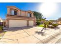 Attractive two-story home featuring a spacious driveway leading to a two-car garage, all set under a clear blue sky at 13025 W Gelding Dr, El Mirage, AZ 85335