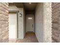 A covered entryway leads to a front door, framed by brick accents and a sidelight window at 13314 W Dale Ln, Peoria, AZ 85383