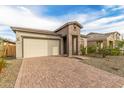 Well-manicured lawn and brick driveway leading up to a home with a two-car garage at 13314 W Dale Ln, Peoria, AZ 85383