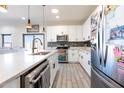 Bright kitchen with stainless steel appliances, white cabinets, an island with a gold faucet and stylish tile flooring at 13350 W La Reata Ave, Goodyear, AZ 85395