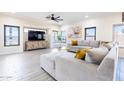 Spacious living room features a comfortable sectional sofa, a ceiling fan, and several large windows at 13350 W La Reata Ave, Goodyear, AZ 85395