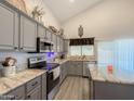 Well-appointed kitchen with gray cabinets, granite countertops, stainless steel appliances, and center island at 1357 N Balboa Dr, Gilbert, AZ 85234