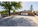 Beautifully landscaped single-story home with a two-car garage and mature trees at 1755 W Lawrence Ln, Phoenix, AZ 85021