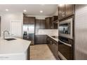 Close up of stainless steel appliances and dark cabinets in a modern kitchen at 17842 W Getty Dr, Goodyear, AZ 85338