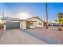 Inviting single-story home featuring a gray attached garage and desert landscaping at 2301 E Alpine E Ave, Mesa, AZ 85204