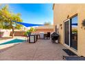 Spacious backyard patio with an outdoor kitchen, built-in grill, and shaded dining area at 2478 W Allens Peak Dr, San Tan Valley, AZ 85144