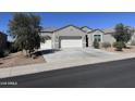 Charming single-story home featuring a gray stucco exterior, a two-car garage, and low maintenance landscaping at 2994 N 305Th Dr, Buckeye, AZ 85396