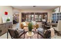 Cozy living room with plantation shutters, a comfortable leather sofa, and a dining area at 4411 E Spur Dr, Cave Creek, AZ 85331