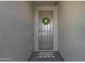 Inviting front entrance featuring a gray front door adorned with a wreath and a stylish welcome mat at 4595 W Stonecrop Dr, San Tan Valley, AZ 85144