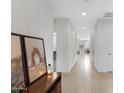 Bright hallway with tile flooring, white walls, and stylish decor leading to the dining area at 4595 W Stonecrop Dr, San Tan Valley, AZ 85144