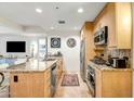 Stylish kitchen features granite counters, stainless steel appliances, and travertine floors at 7121 E Rancho Vista Dr # 2002, Scottsdale, AZ 85251