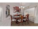 The dining area features a wooden table, chairs, chandelier, and decorative cabinets at 15240 W Melissa Ln, Surprise, AZ 85374