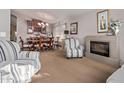 Living room with fireplace and adjoins dining area with cabinet and window at 15240 W Melissa Ln, Surprise, AZ 85374