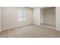 Bright living room featuring neutral walls, plush carpet, and large window at 17851 W Getty Dr, Goodyear, AZ 85338