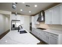 Modern kitchen with stainless steel appliances, white cabinets, and quartz countertops at 2113 N 210Th Ave, Buckeye, AZ 85396