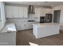 Bright kitchen features stainless appliances, white cabinets, quartz counters, tile backsplash and island at 2443 W Rowel Rd, Phoenix, AZ 85085