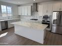 Modern kitchen with stainless steel appliances, white cabinets, quartz countertops, and a center island at 2443 W Rowel Rd, Phoenix, AZ 85085