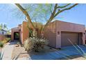 Cozy desert home with private two-car garage surrounded by decorative rock and drought-resistant plants at 32960 N 70Th St, Scottsdale, AZ 85266