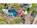 Aerial view of a backyard pool with a red umbrella, lounge area and surrounding landscaping at 4114 E Desert Cove Ave, Phoenix, AZ 85028