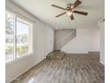 Bright living room featuring wood-look tile floors, a large window, and a staircase at 5112 N 83Rd St, Scottsdale, AZ 85250