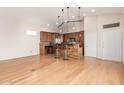 Open concept kitchen with wooden cabinets, granite countertops, pendant lighting, and hardwood floors at 5303 N 7Th St # 242, Phoenix, AZ 85014