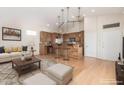 Open-concept living room and kitchen featuring modern lighting, natural wood accents, and bright, open spaces at 5303 N 7Th St # 242, Phoenix, AZ 85014