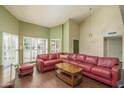 Bright living room features vaulted ceiling, plantation shutters and comfortable leather seating area at 5434 W Desert Hills Dr, Glendale, AZ 85304