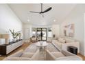Spacious living room with vaulted ceilings, hardwood floors, and modern furnishings at 7553 E Woodshire Cv, Scottsdale, AZ 85258
