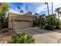Three-car garage exterior showcasing desert landscaping and a meticulously maintained front yard at 8737 E San Vicente Dr, Scottsdale, AZ 85258