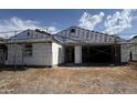 Exterior view of a house under construction with scaffolding showing the layout of the entryway and garage at 15781 W Cheryl Dr, Waddell, AZ 85355