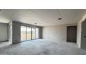 An interior view of a living room featuring large sliding glass doors and unfinished drywall, ready for customization at 15781 W Cheryl Dr, Waddell, AZ 85355
