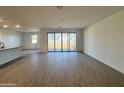 Spacious living room with wood-look flooring and a large sliding glass door at 15781 W Cheryl Dr, Waddell, AZ 85355